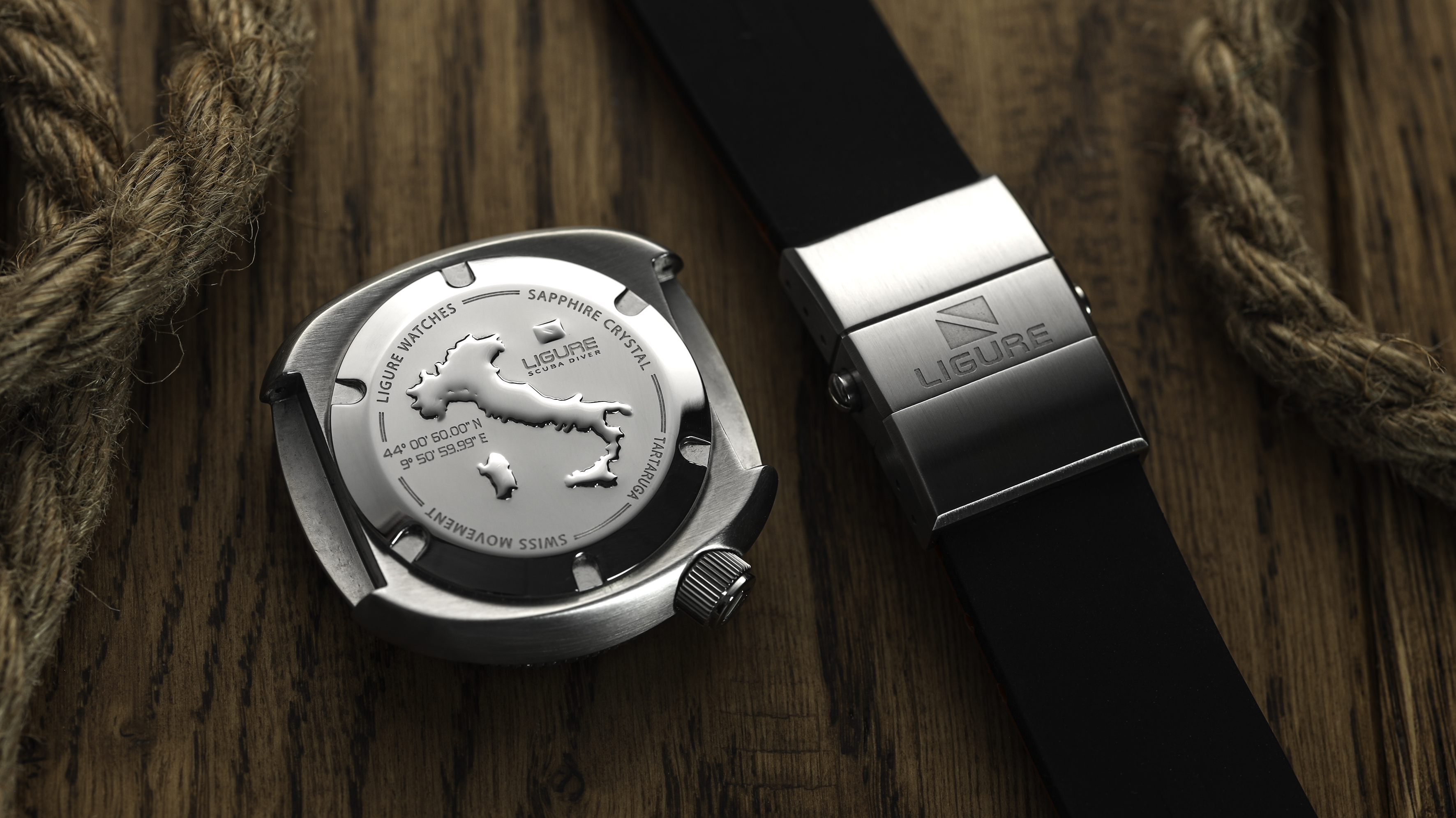 Close-up of the Tartaruga case back showing the embossed outline of Italy and engraved details beside the rubber strap deployment clasp