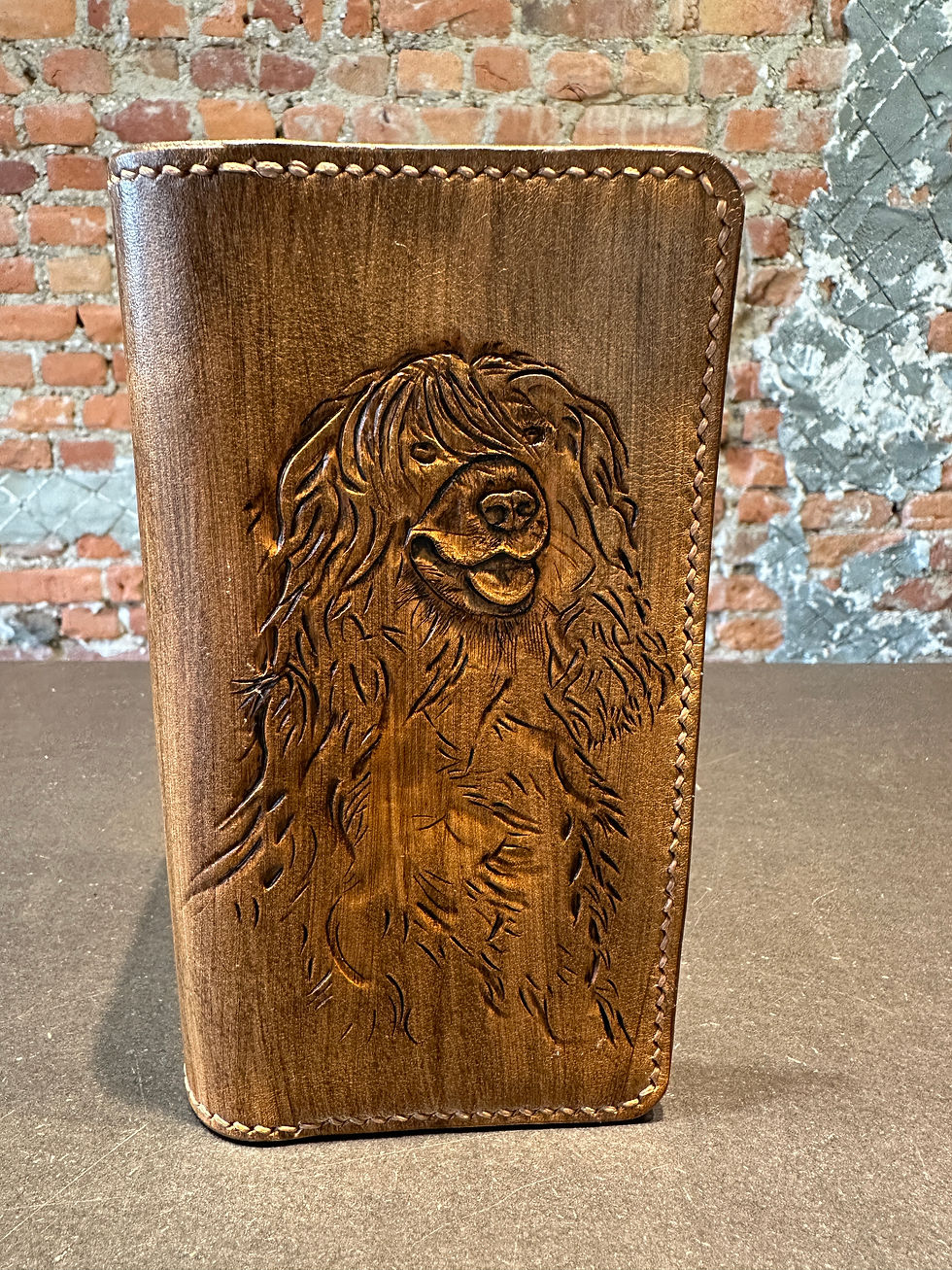 Een vover voor een gsm. met leathercarving de afbeelding overgebracht. met de hand genaaid