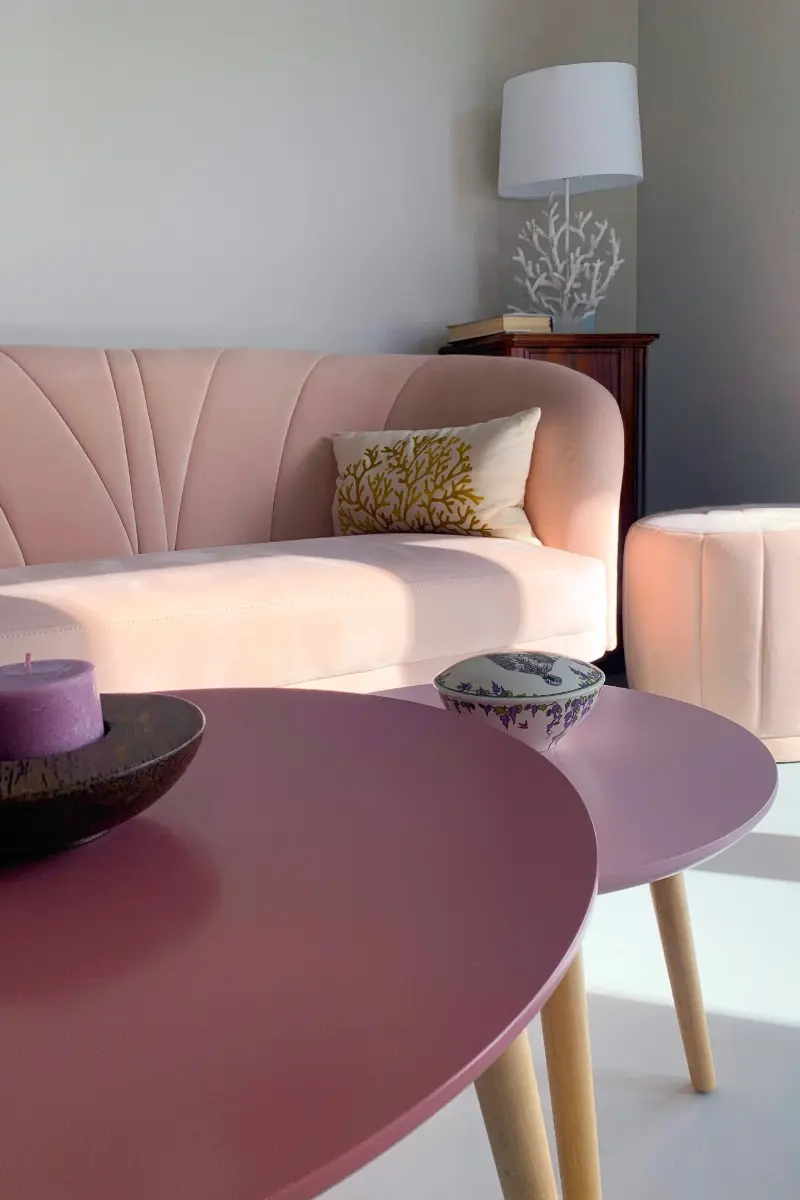 Salon contemporain aux tons poudres avec canape rose, tables basses assorties et decoration elegante dans un logement neuf a Lyon Vaise