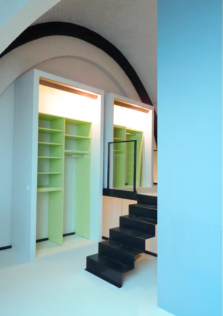 Dressing sur mesure en double hauteur avec escalier noir contemporain et aménagement intérieur sous voûte dans un appartement rénové.
