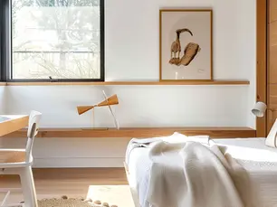 Aménagement d’un petit appartement avec mobilier sur mesure en bois, bureau intégré et optimisation de l’espace.