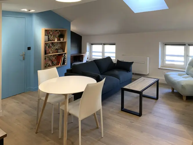 Salon contemporain sous combles avec espace repas, mobilier intégré, bibliothèque sur mesure et aménagement intérieur optimisé dans un appartement rénové