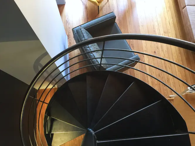 Escalier hélicoïdal en acier noir dans un appartement rénové par architecte d’intérieur à Lyon Croix-Rousse