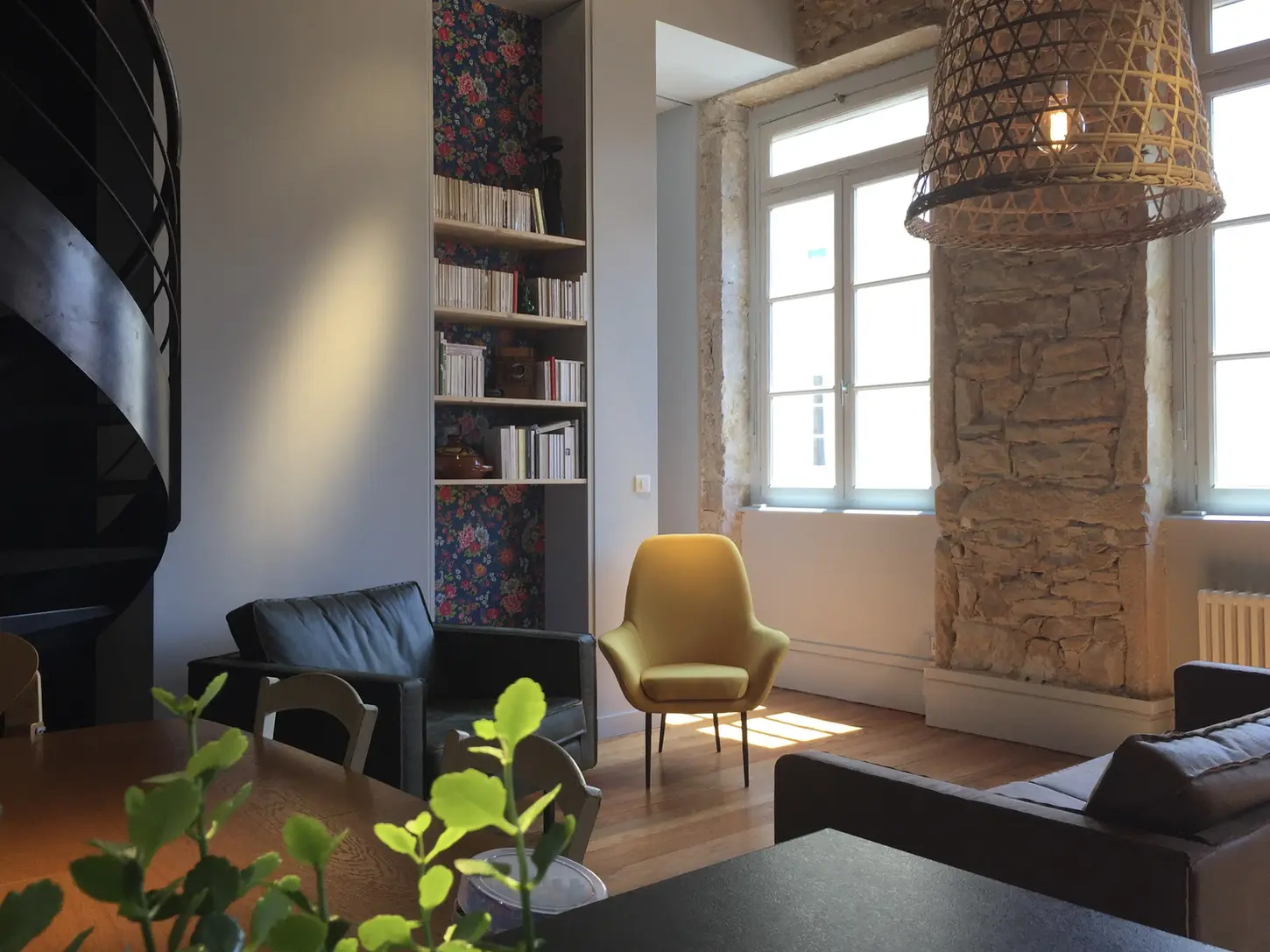 Bibliothèque encastrée sur mesure avec papier peint floral et fauteuil design dans un appartement rénové à Lyon Croix-Rousse