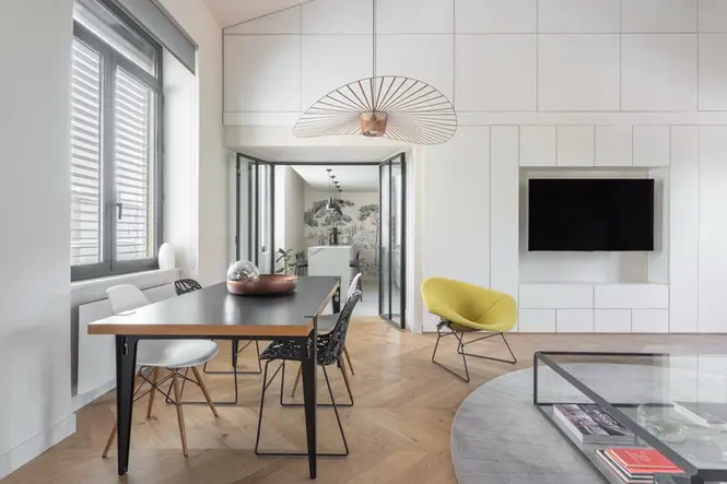 Amenagement interieur avec salle a manger design, parquet point de Hongrie, rangement mural sur mesure et renovation contemporaine realisee par architecte interieur.