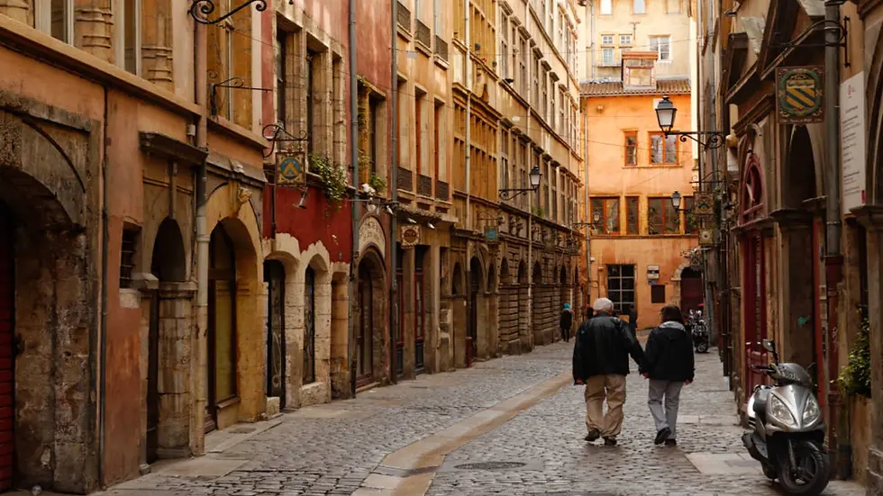 Rue pavée du Vieux Lyon avec immeubles Renaissance et façades historiques colorées.