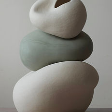 Composition of three ceramic forms stacked on top of each other, showcasing balanced shapes and textures.