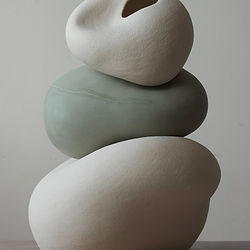 Composition of three ceramic forms stacked on top of each other, showcasing balanced shapes and textures.