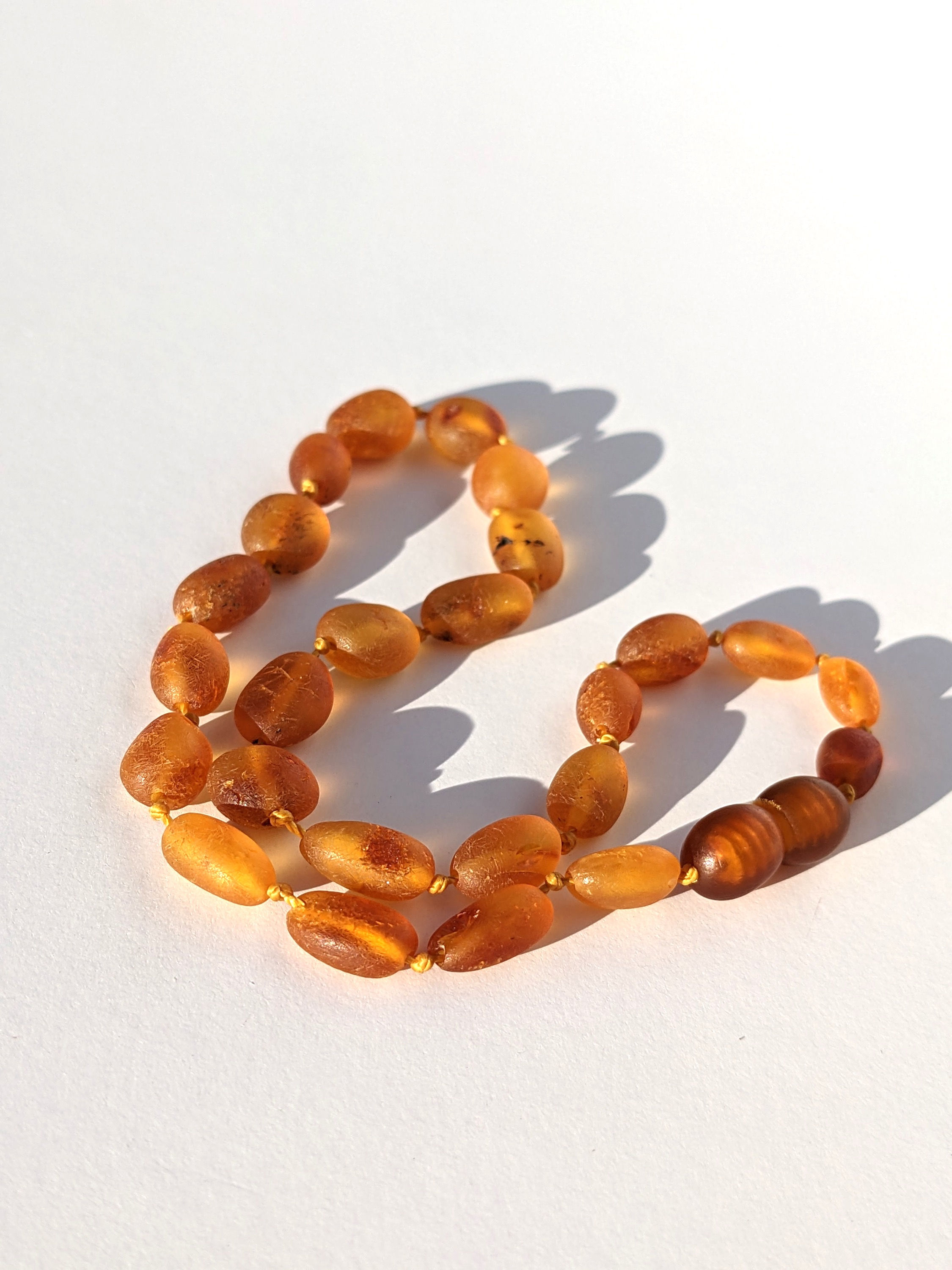 Authentic Baltic Amber children's teething necklace that is 11'' inches long with a screw clasp