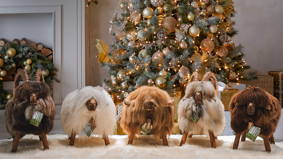 Schafhocker die vor dem Weihnachtsbaum auf einem Schaffell stehen