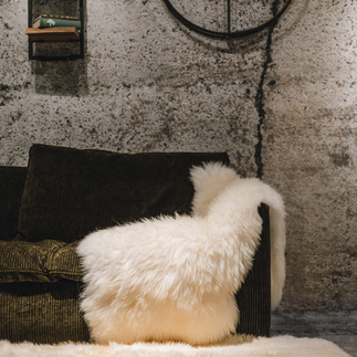 Weißes Lammfell liegt über Couch