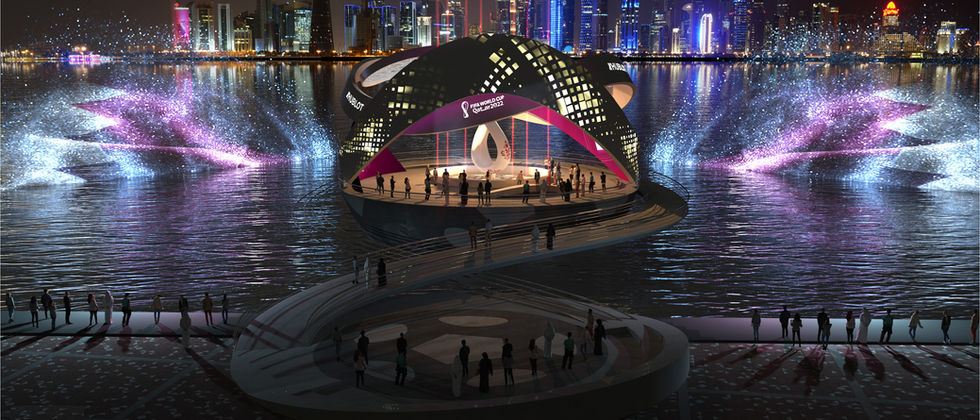 Countdown Clock World Cup 22: Countdown-Pavillon bei Nacht mit farbigen Projektionen, Wasserfontänen und einer Stadtsilhouette im Hintergrund.