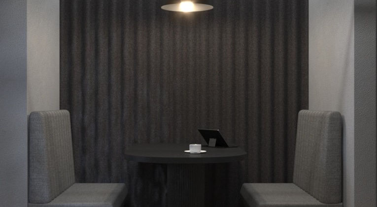 Büro In Stalinbauten Berlin: Zwei gepolsterte Sitzbänke mit kleinem Tisch vor einer dunklen Lamellenwand.