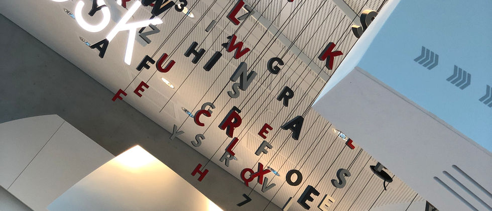 Funke Medien Gruppe- Kiosk: Blick nach oben auf einzeln abgehängte Buchstaben und den leuchtenden Kiosk-Schriftzug.
