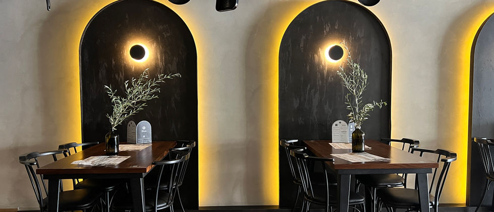 Mustache Restaurant : Dunkle Bogennischen mit warmem Lichtkranz, Menüs und kleinen Restauranttischen.