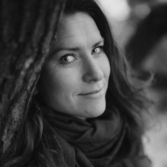 Donker buitenportret van vrouw met subtiel licht op het gezicht