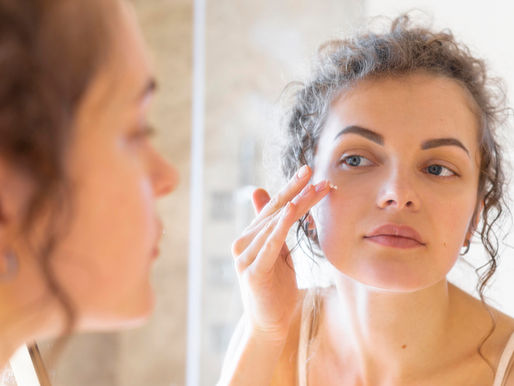 a woman doing her skincare routine in the mirror