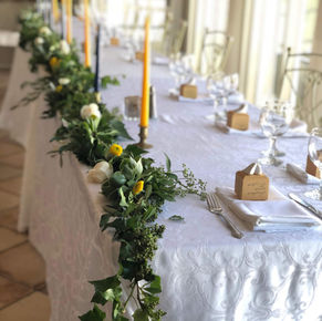 Intimate sweetheart table adorned with roses and candles, eucalyptus garland at Grand Island Mansion.