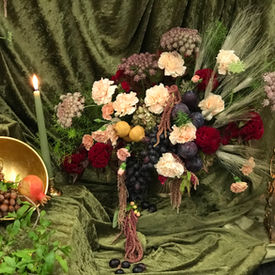 Vivid fruit and floral centerpiece with watermelon, pomegranate, and persimmon designed for a luxury Bay Area Mehregan.