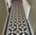 A hallway with striking black and white geometric pattern flooring