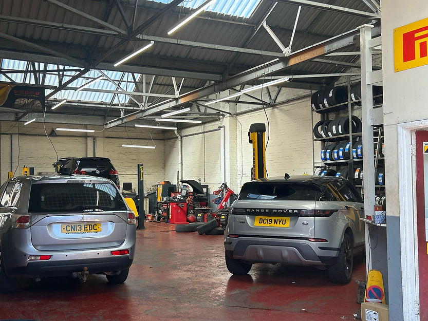 Two silver cars in our garage awaiting service.