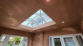 Freshly plastered room interior with a large pyramid skylight in the ceiling