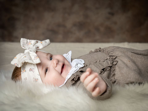 Babyfotografering af pige liggende på lammeskind