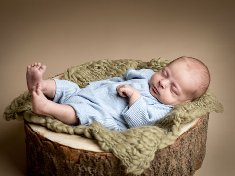 Baby fotografering af nyfødt liggende i træstub