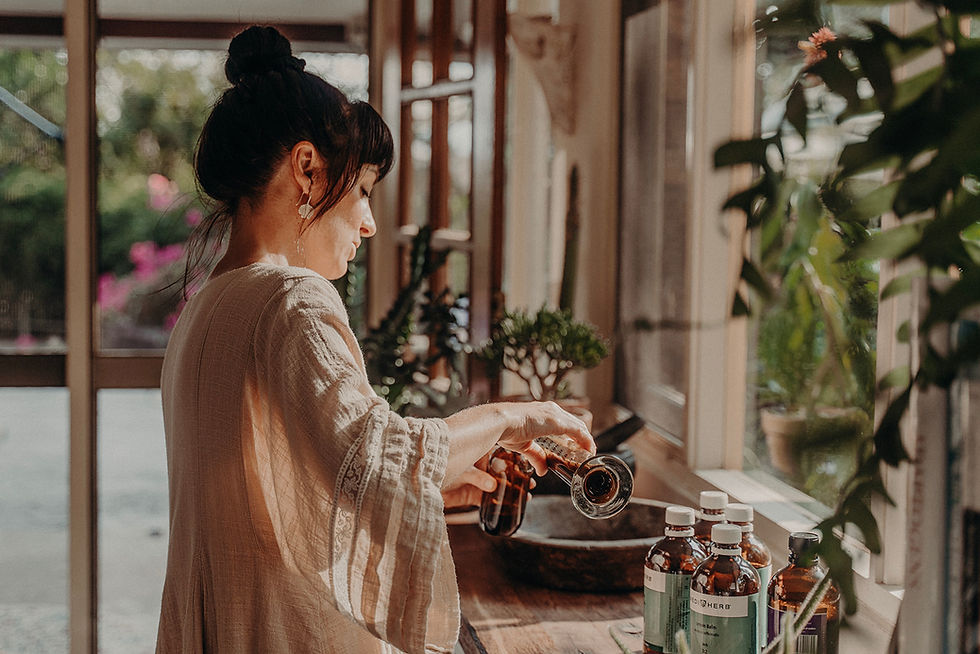 Naturopath, Rachel Bonello mixing and pouring herbs in her clinic dispensary.