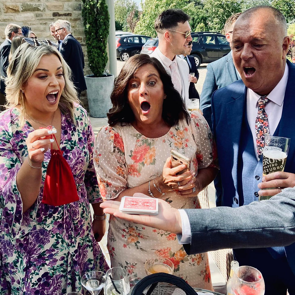Wide angle view of a magician performing an illusion on a stage at a North Yorkshire wedding venue with guests watching