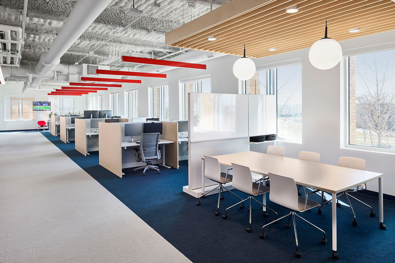 Bright open office plan with cubicles and a meeting table