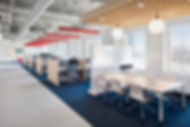 Bright open office plan with cubicles and a meeting table