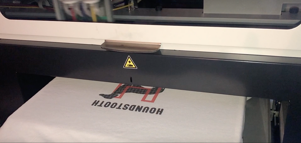 A screen printer that is printing a shirt