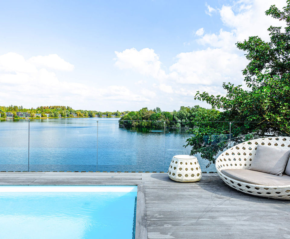 Rooftop swimming pool and comfy chair on the roof looking out to the lake at the Pool House rooftop swimming pool and hot tub.