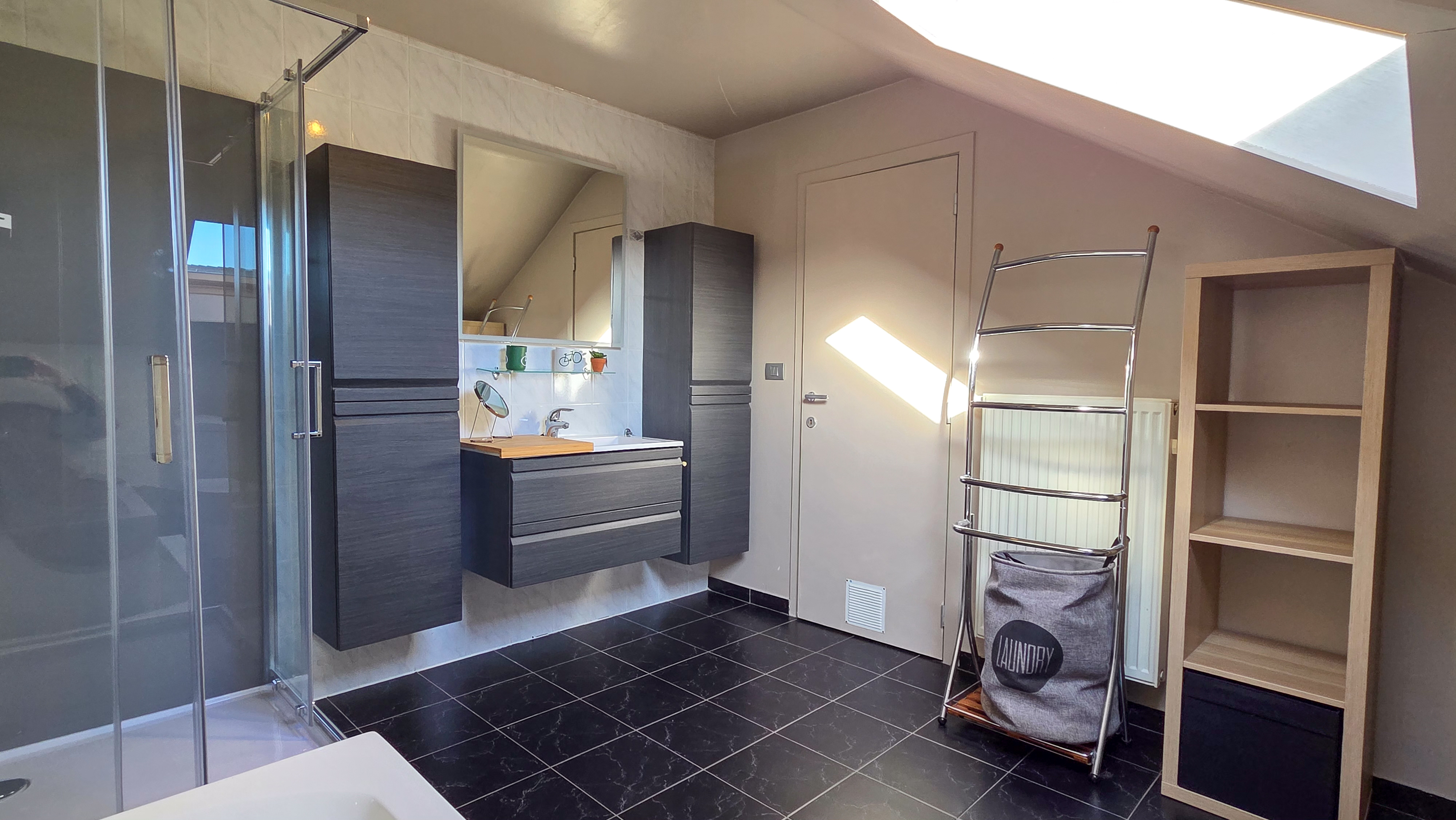 Badkamer met bad en douche