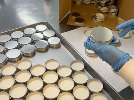 sunscreen tins being filled in a lab