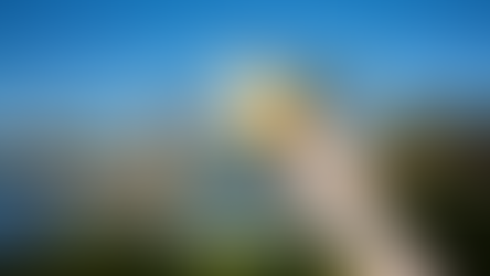 A ladies hand holding Universal Studios Orlando Park Tickets in the air in front of the Universal globe at the park entrance in City Walks to show and explain the ticket differences.