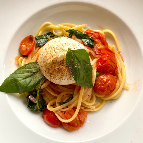 Pasta mit Burrata, Taggiasca-Oliven und Kirschtomaten auf mediterranem Teller