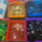 Colorful bins filled with assorted LEGO pieces on a table. Bins contain different colors and shapes, with a bright and playful atmosphere.