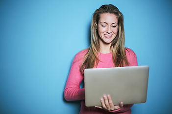 woman in pink long sleeve shirt holding silver laptop