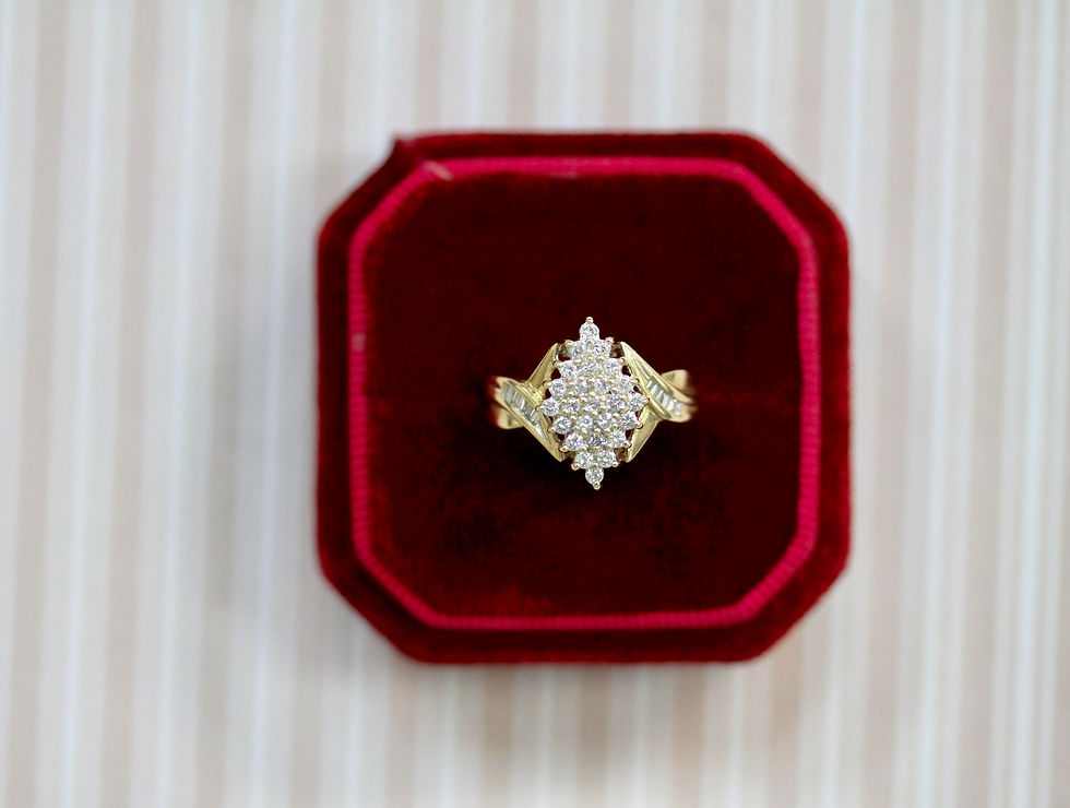 Gold ring encrusted with diamonds sits in a red velvet box against a striped background, evoking elegance and luxury.