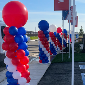 Red, white, and blue balloon columns line a pathway