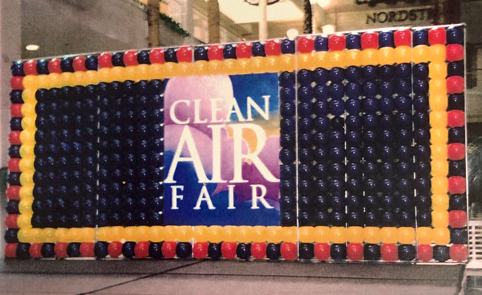 a sign for the clean air fair is surrounded by balloons