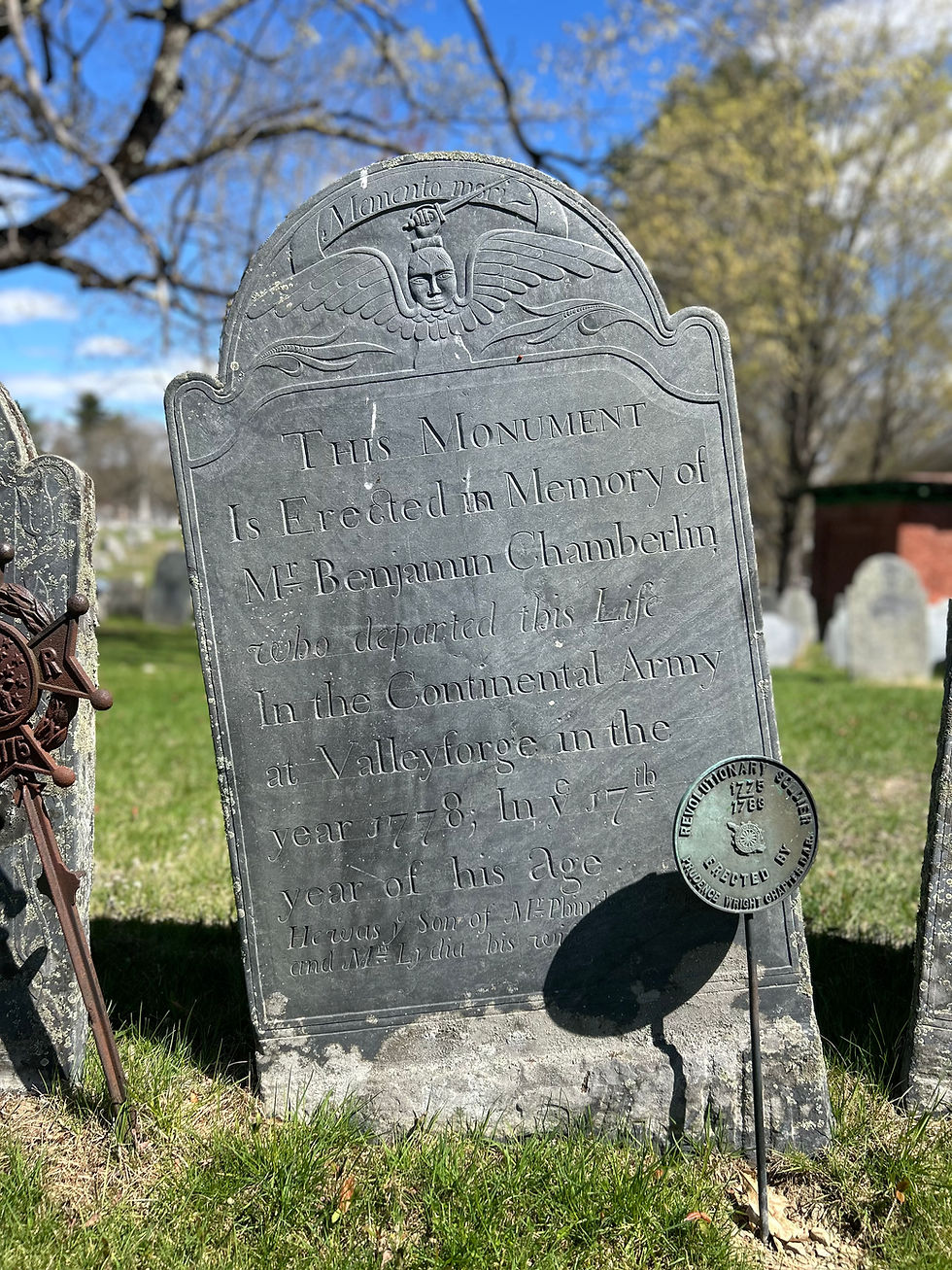 Slate gravestone with a winged face topped with a sword in hand