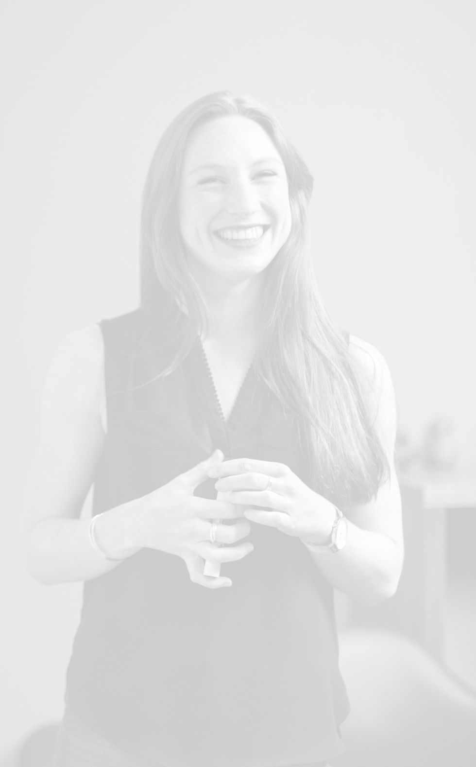 Smiling woman, hands clasped, professional headshot