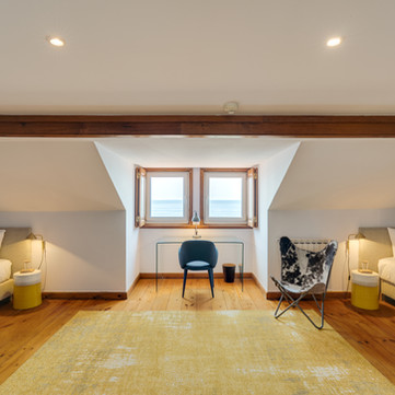 Two beds in a room with a window and a butterfly chair. Blissful Seafront