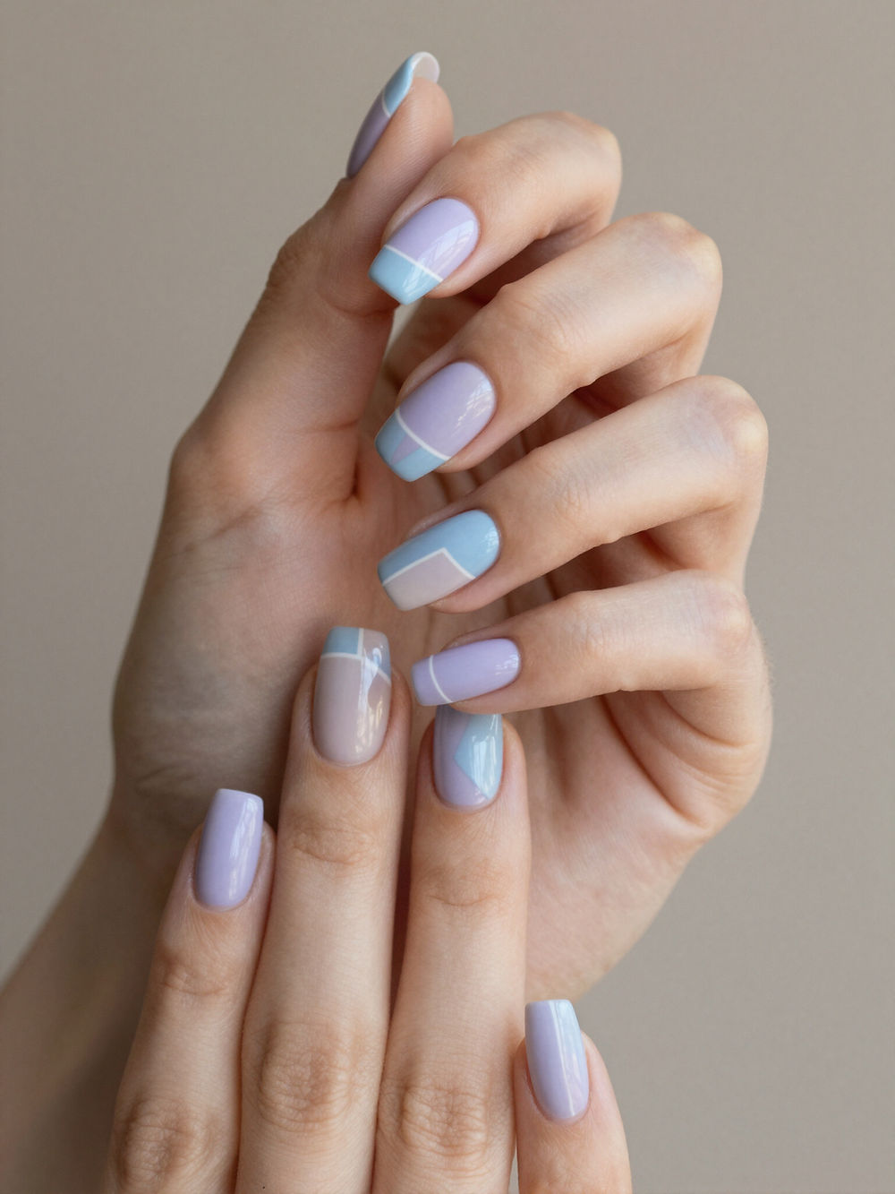 Hands with pastel blue and purple geometric nail art