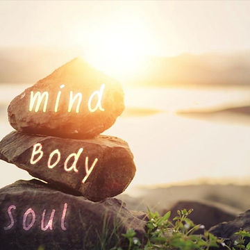 A picture of a scenic back drop with three large stones and the words mind body and soul