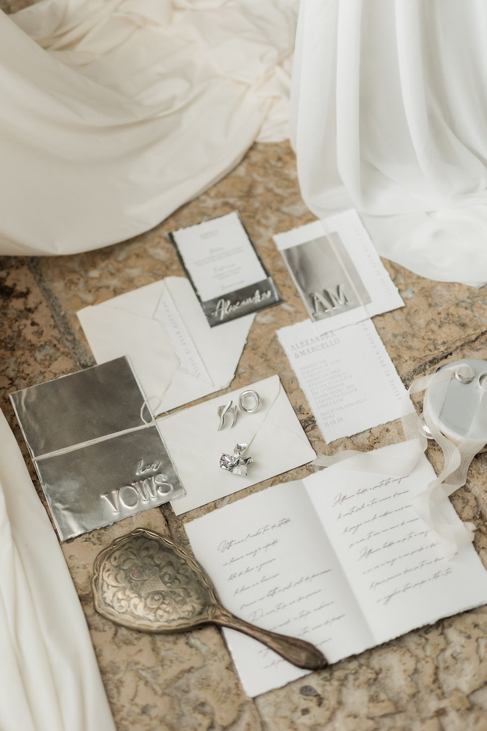 Luxury wedding flat lay with bridal stationery, vow books, invitations, and elegant accessories