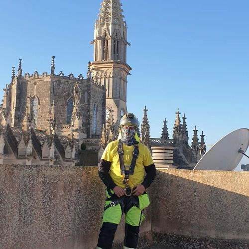 realizando limpieza de fachadas en un edificio alto en Valencia